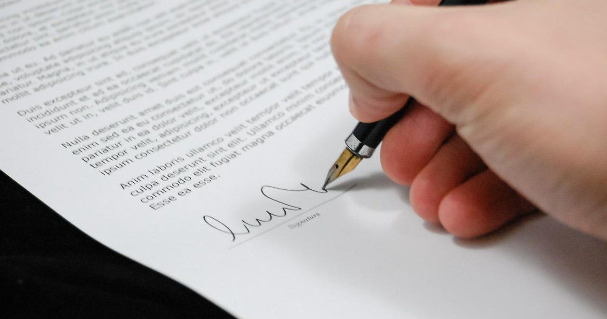 Contrato e documentos impressos sobre a mesa, em análise de empréstimo consignado