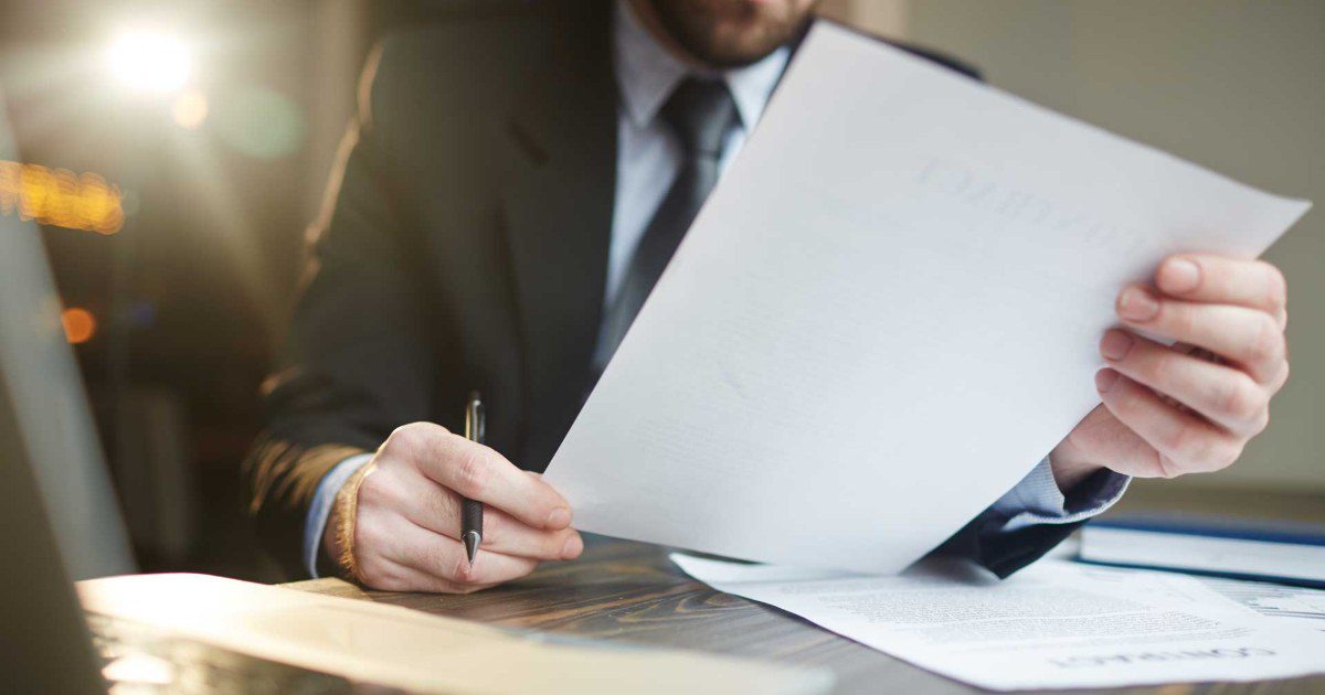 Documentos e boletos sobre a mesa sendo analisados por advogado